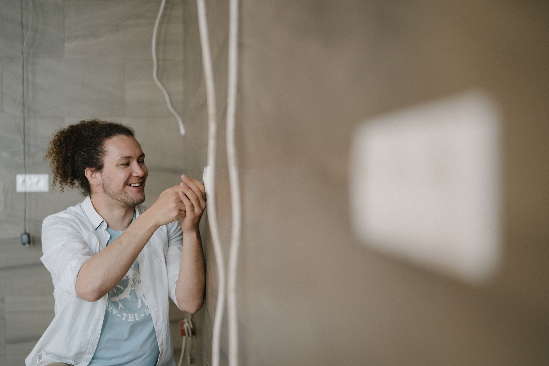 Electrician installing a wall outlet indoors